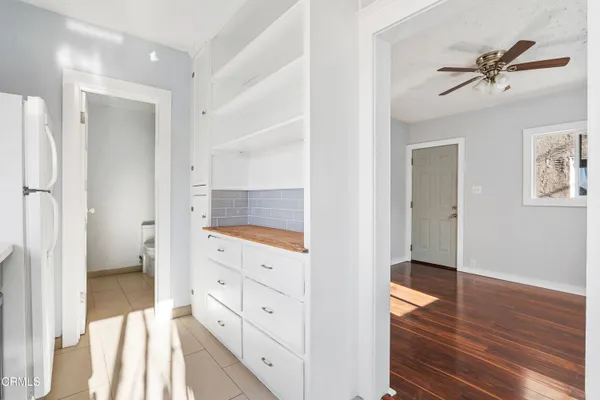 a view of a hallway with wooden floor and cabinet