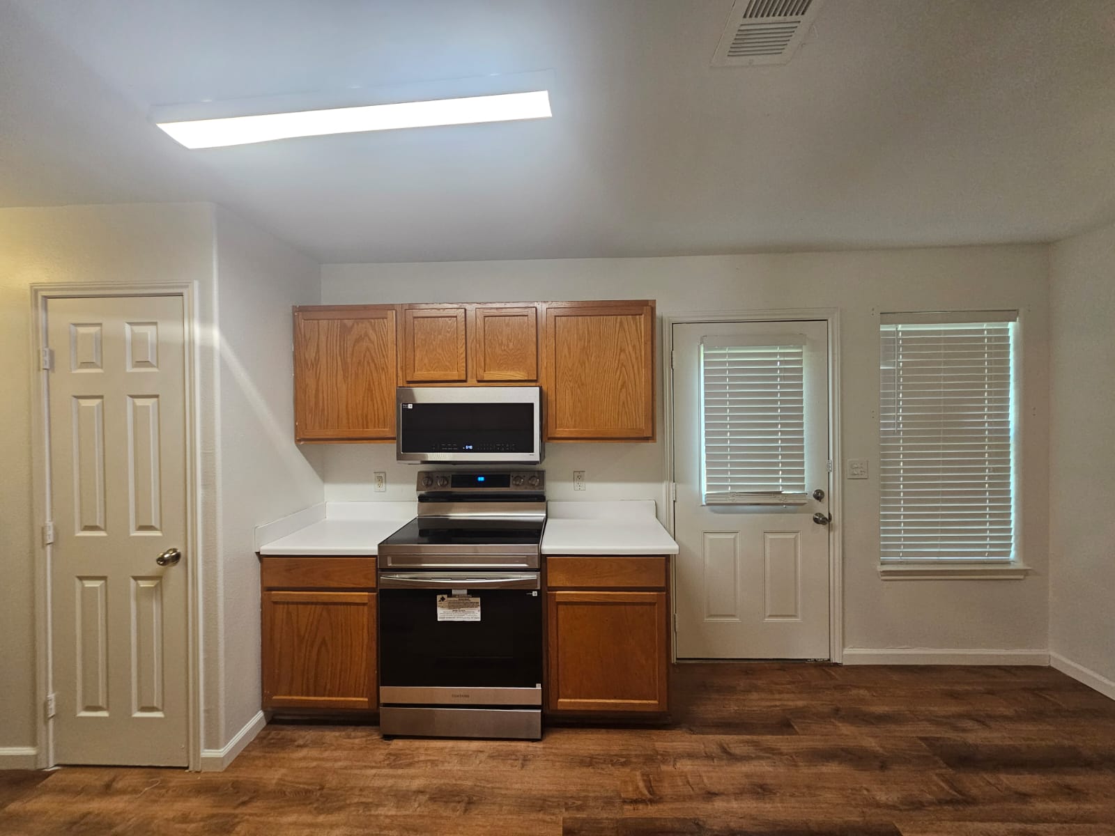 606 Trinity Street Lockhart, TX 78644 - Photo 6 of 23 A well-appointed kitchen showcasing durable wood-look flooring and efficient appliance placement.