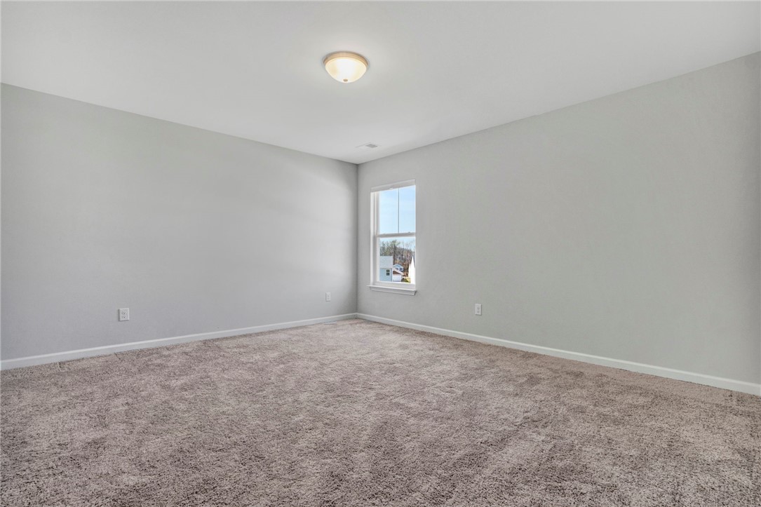 270 Pendergast Road Greenville, SC 29605 - Photo 31 of 43 An inviting room awaits personalization, featuring neutral walls and plush carpeting, illuminated by natural light from a well-placed window.