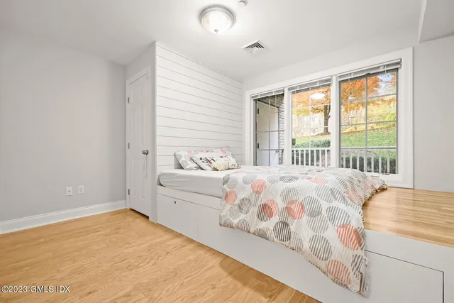 a bedroom with a bed and a large window