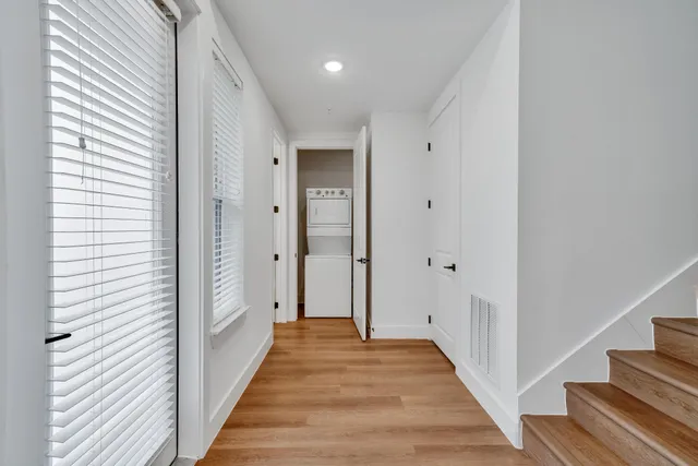 a view of a hallway with wooden floor and staircase