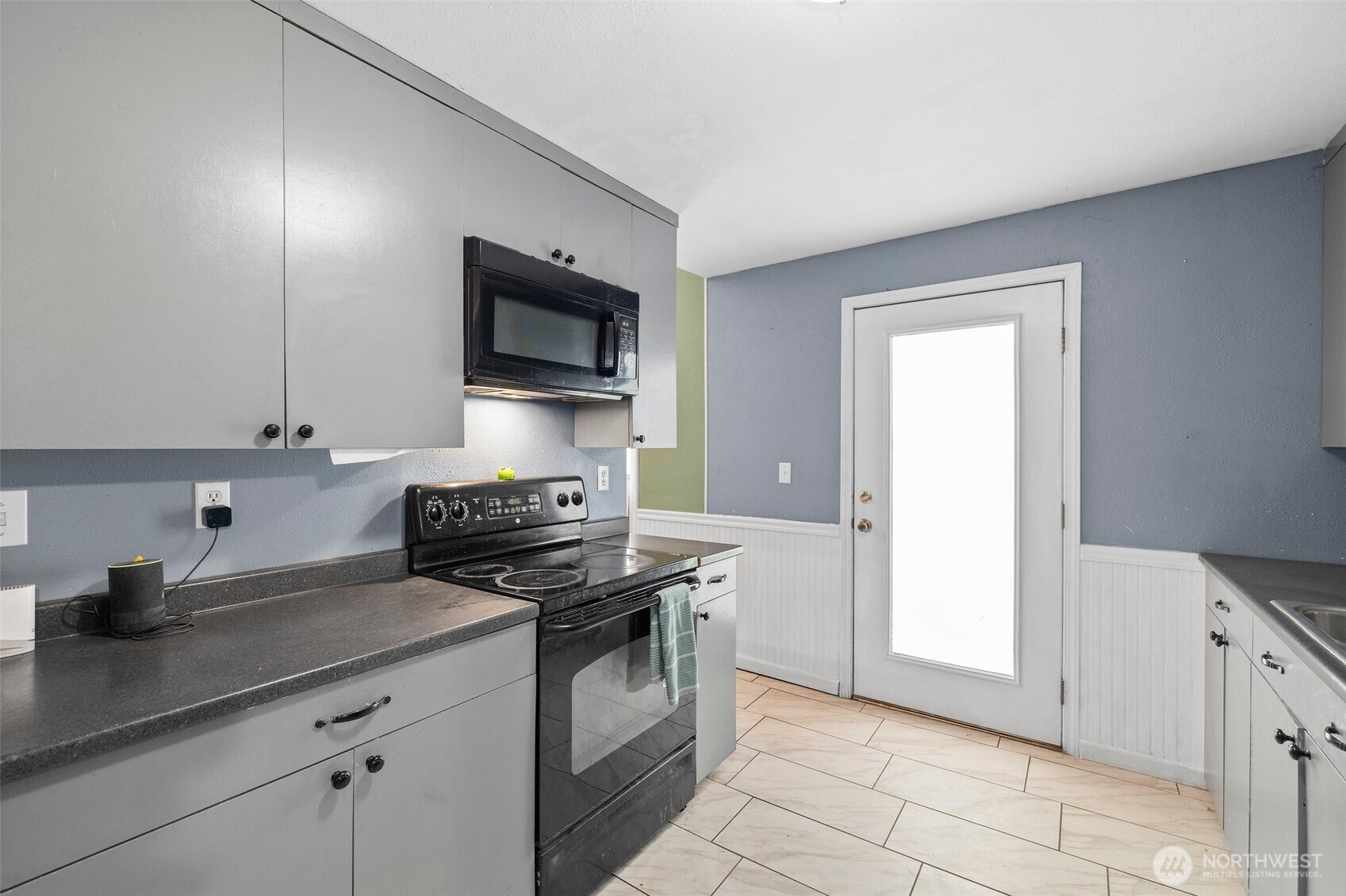 3710 Rucker Avenue Everett, WA 98201 - Photo 16 of 33 a kitchen with granite countertop a sink dishwasher stove and cabinets