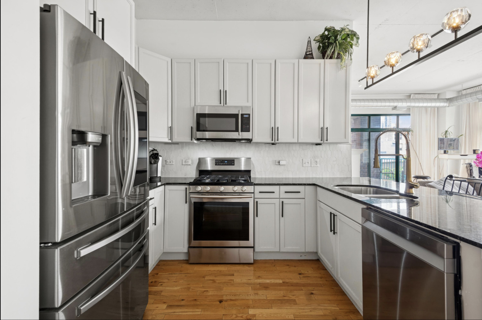 910 West Madison Street, Unit 408 Chicago, IL 60607 - Photo 4 of 16 a kitchen with stainless steel appliances granite countertop a refrigerator sink and stove