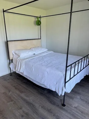 a bedroom with a bed and wooden floor