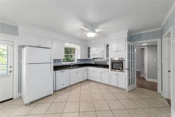 a kitchen with white cabinets stainless steel appliances and a refrigerator