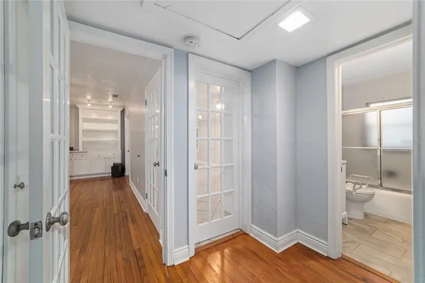 a view of a bathroom with wooden floor and a glass door shower