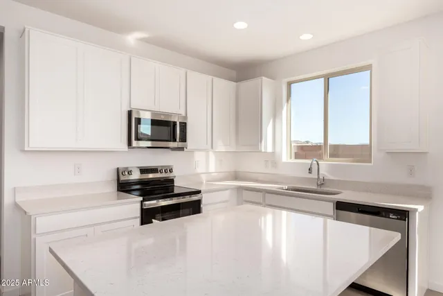 a kitchen with granite countertop a sink a stove and cabinets