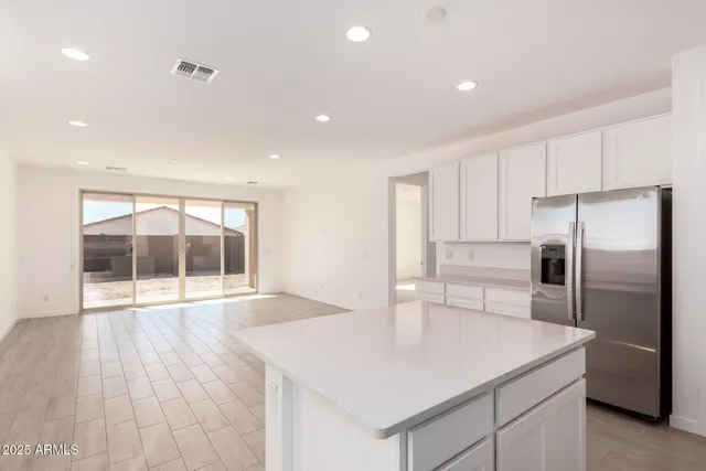 a kitchen with kitchen island a refrigerator a stove and wooden floor