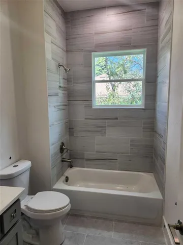 a bath room with a toilet a bath tub and a shower