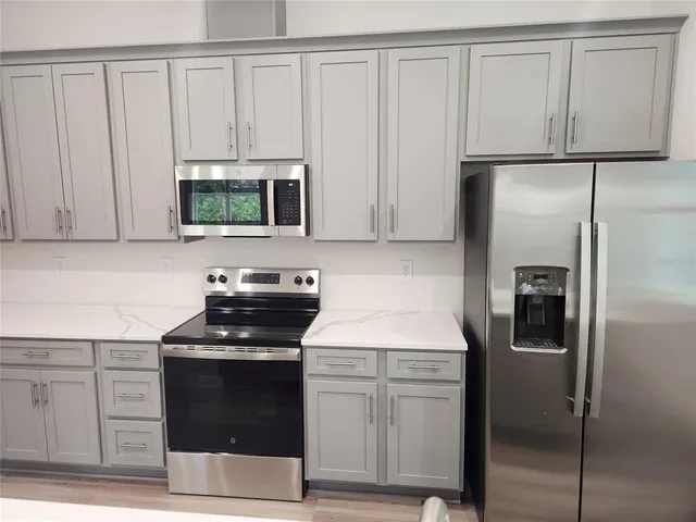 a kitchen with white cabinets and stainless steel appliances