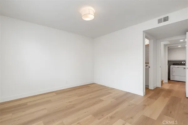 a view of a room with wooden floor and a kitchen