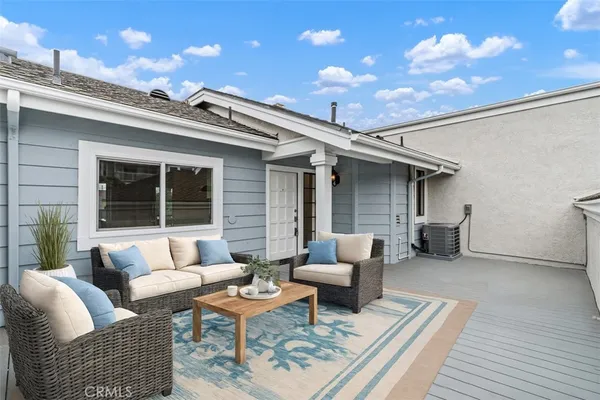 a view of a patio with couches and a table and chairs with wooden floor