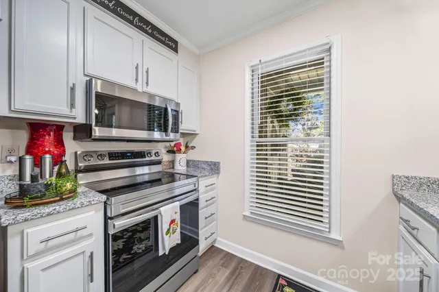 a kitchen with stainless steel appliances a stove microwave and sink