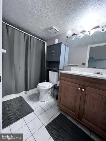 a bathroom with a sink a toilet a mirror and vanity