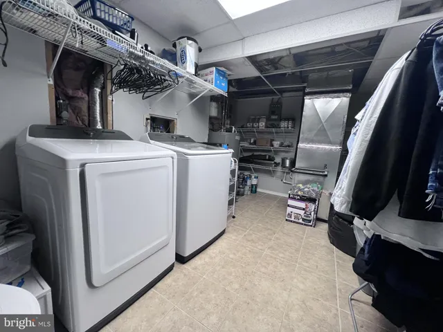 a view of storage and utility room with racks dryer and washer