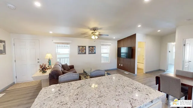 a living room with furniture a large window and a chandelier