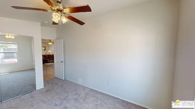 an empty room with an entryway and fan
