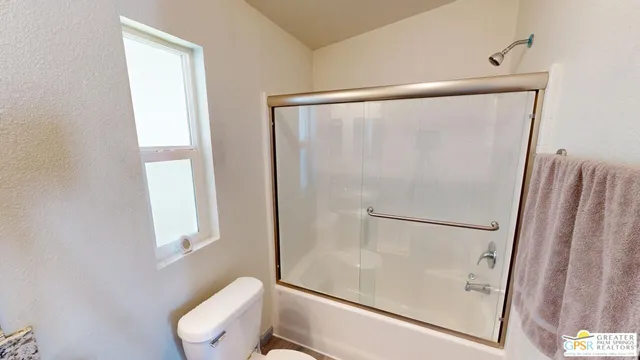 a white toilet sitting next to a shower