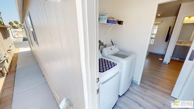 a hallway with wooden floor washer and dryer
