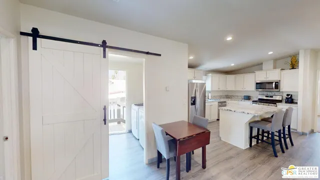 a kitchen with white cabinets and wooden floor