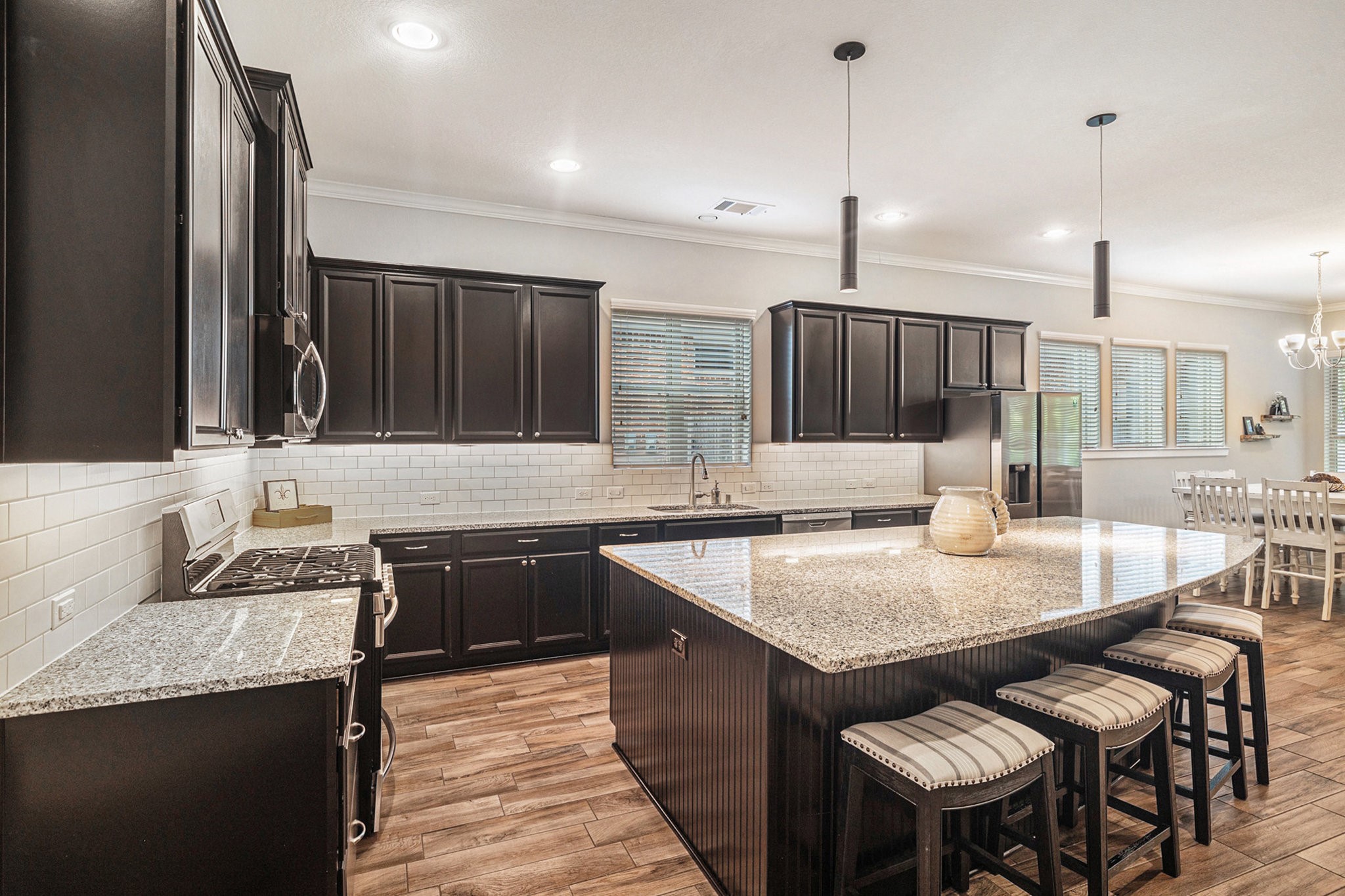 1126 Audrey Trail Tomball, TX 77375 - Photo 9 of 35 a kitchen with granite countertop a stove a sink a counter and chairs
