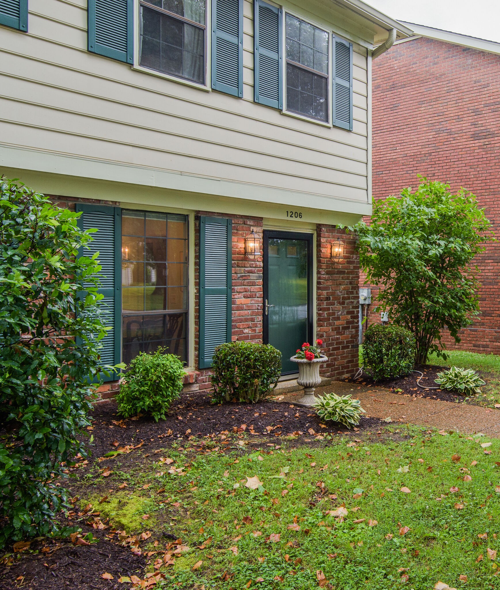 1206 General George Patton Road Nashville, TN 37221 - Photo 3 of 27 a view of a house with brick walls and a yard with plants