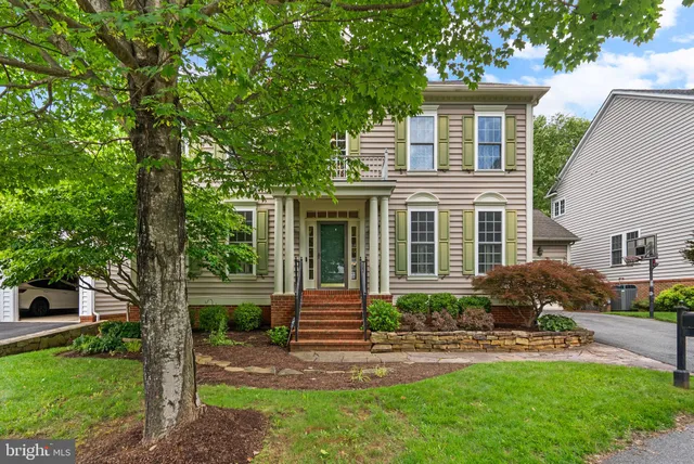 a front view of a house with a yard and potted plants