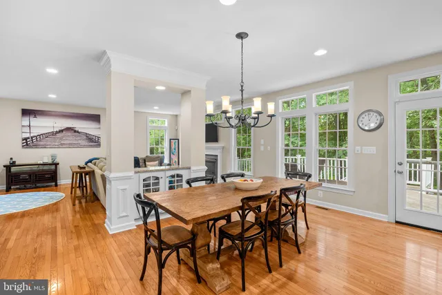 a view of a dining room and livingroom with furniture wooden floor a chandelier