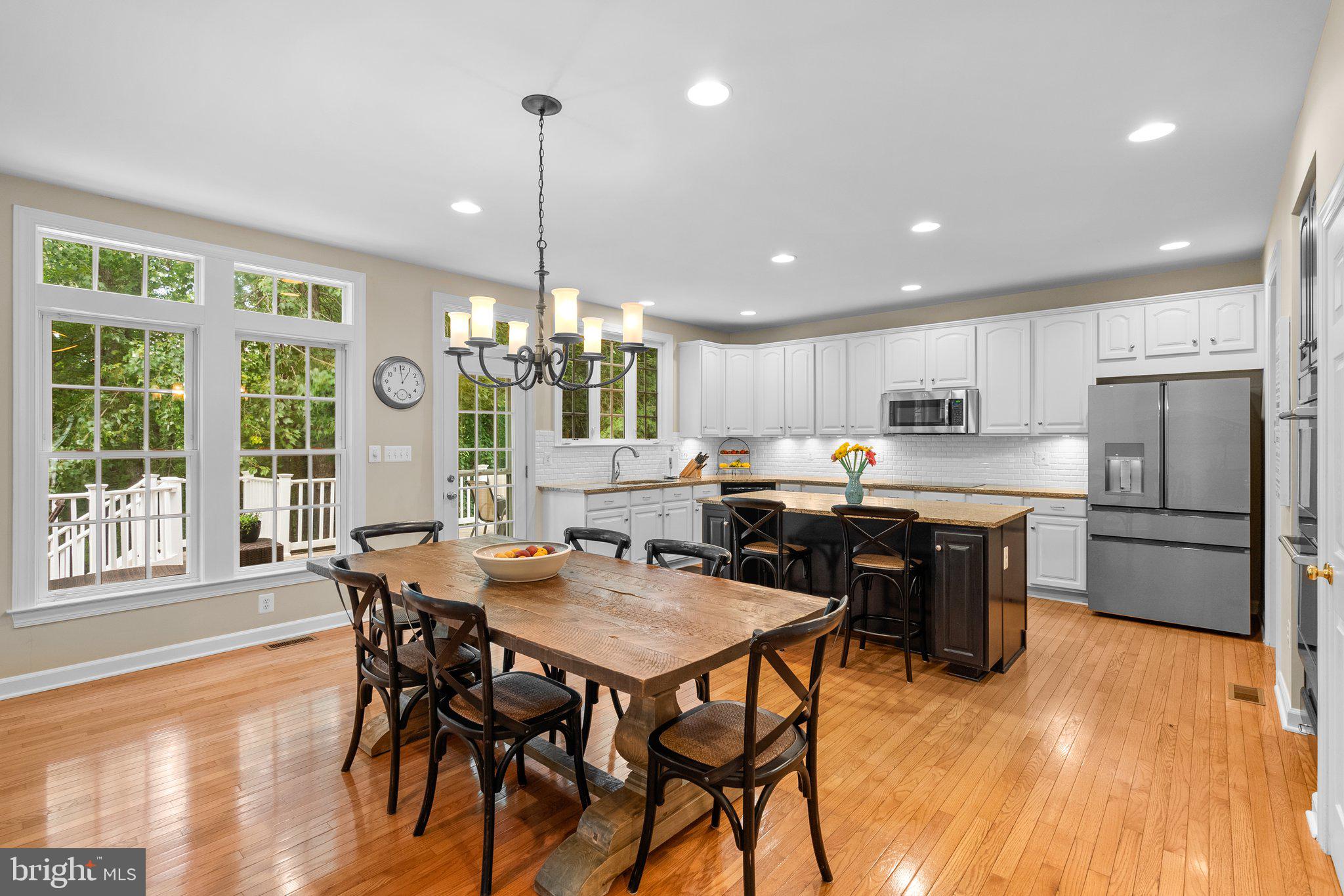 869 Still Creek Lane Gaithersburg, MD 20878 - Photo 8 of 58 a kitchen with stainless steel appliances granite countertop a stove a refrigerator a sink a dining table and chairs with wooden floor