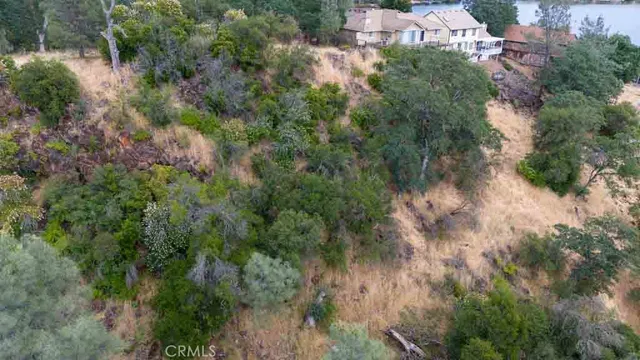 an aerial view of residential house with outdoor space and trees all around