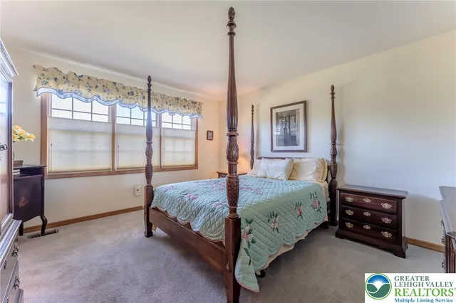 a bedroom with a bed dresser and a large mirror