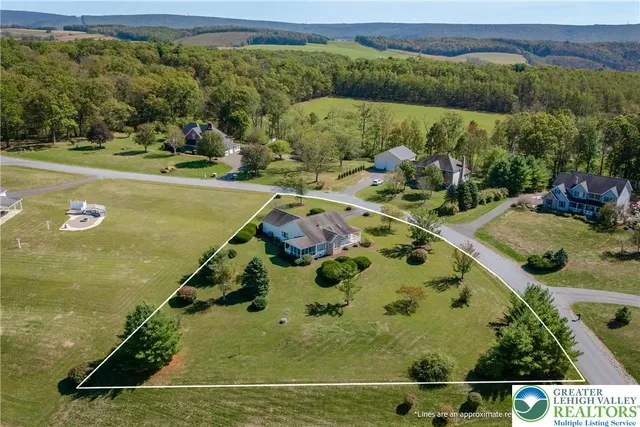 an aerial view of residential houses with outdoor space and lake view
