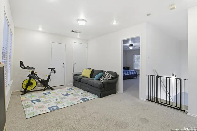 a living room with furniture a flat screen tv and a rug