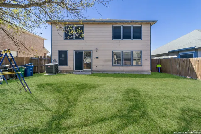 a view of an house with backyard space and a tree
