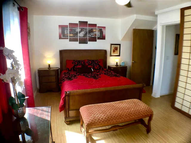 a bedroom with a bed a dresser and a large mirror