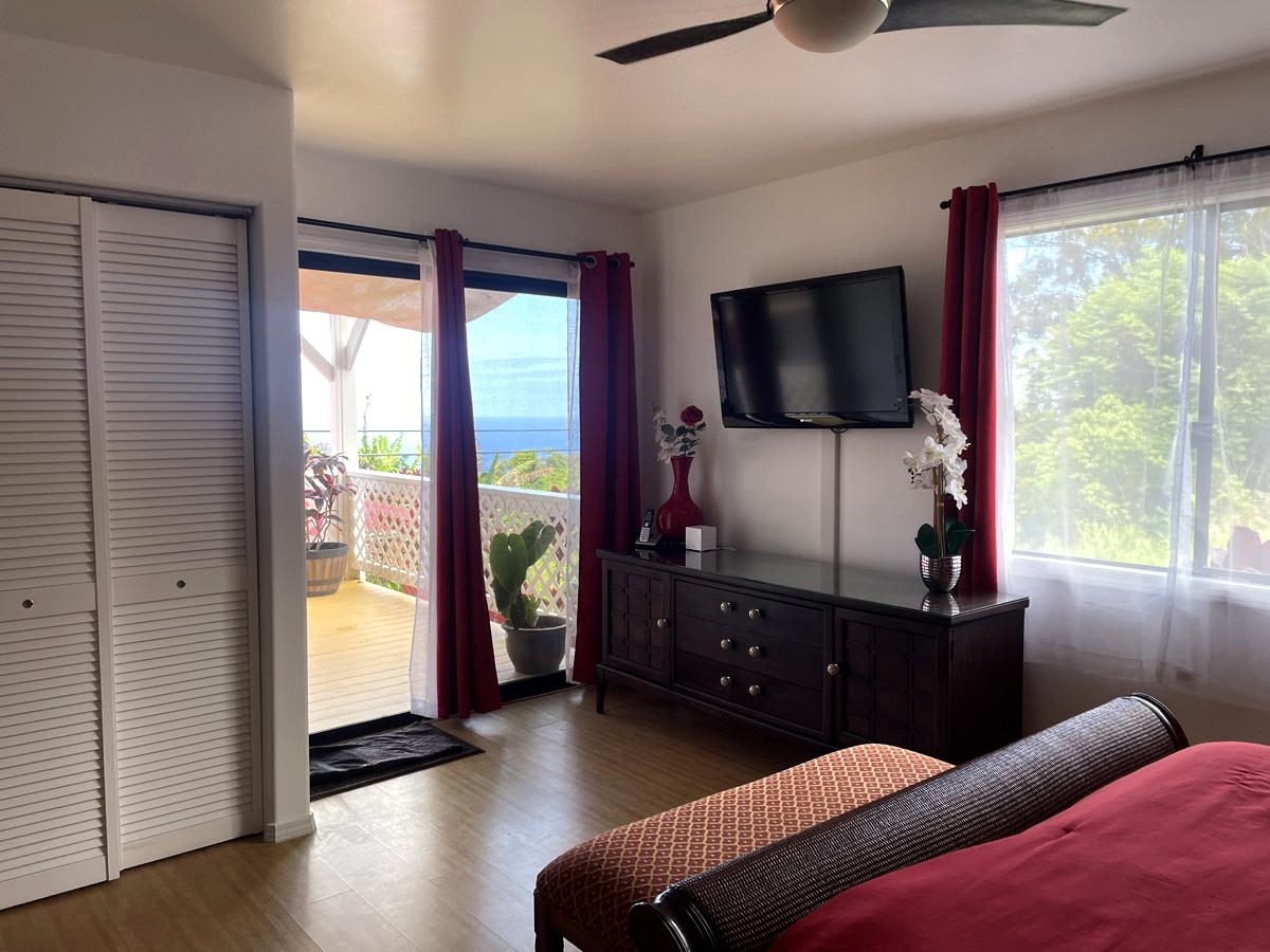979 Hana Highway Haiku, HI 96708 - Photo 16 of 25 a living room with furniture a flat screen tv and floor to ceiling window