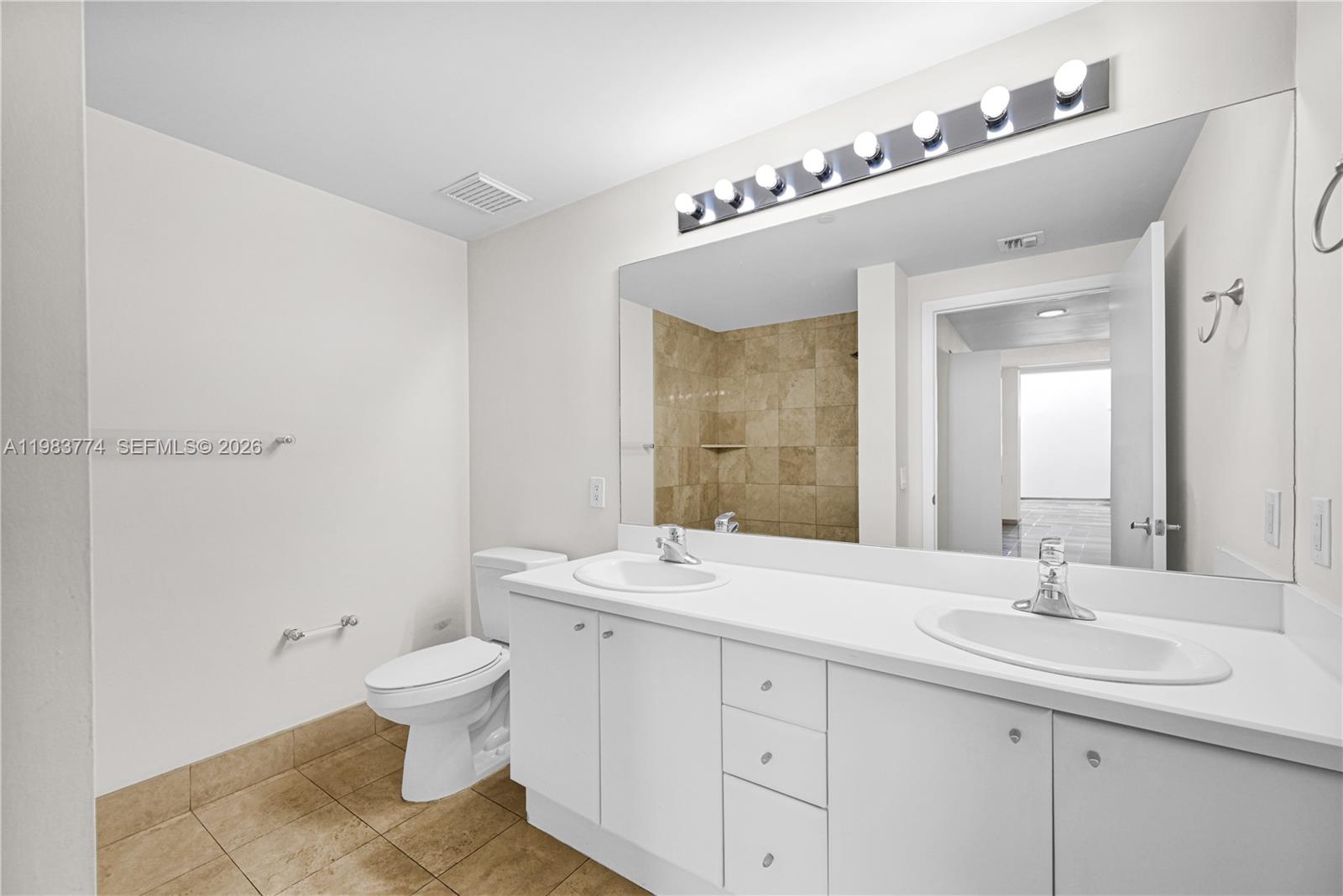 2475 Brickell Avenue, Unit 703 Miami, FL 33129 - Photo 19 of 30 a bathroom with a double vanity sink mirror and toilet
