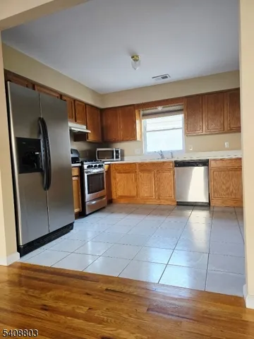 a kitchen with stainless steel appliances granite countertop a refrigerator sink and stove