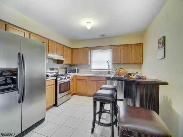 a kitchen with granite countertop stainless steel appliances a sink a counter top space cabinets and stainless steel appliances