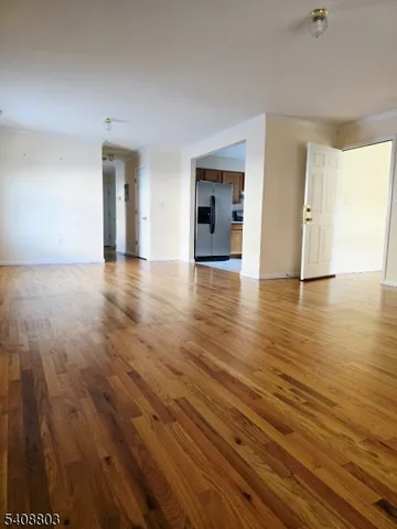 a view of empty room with wooden floor and windows