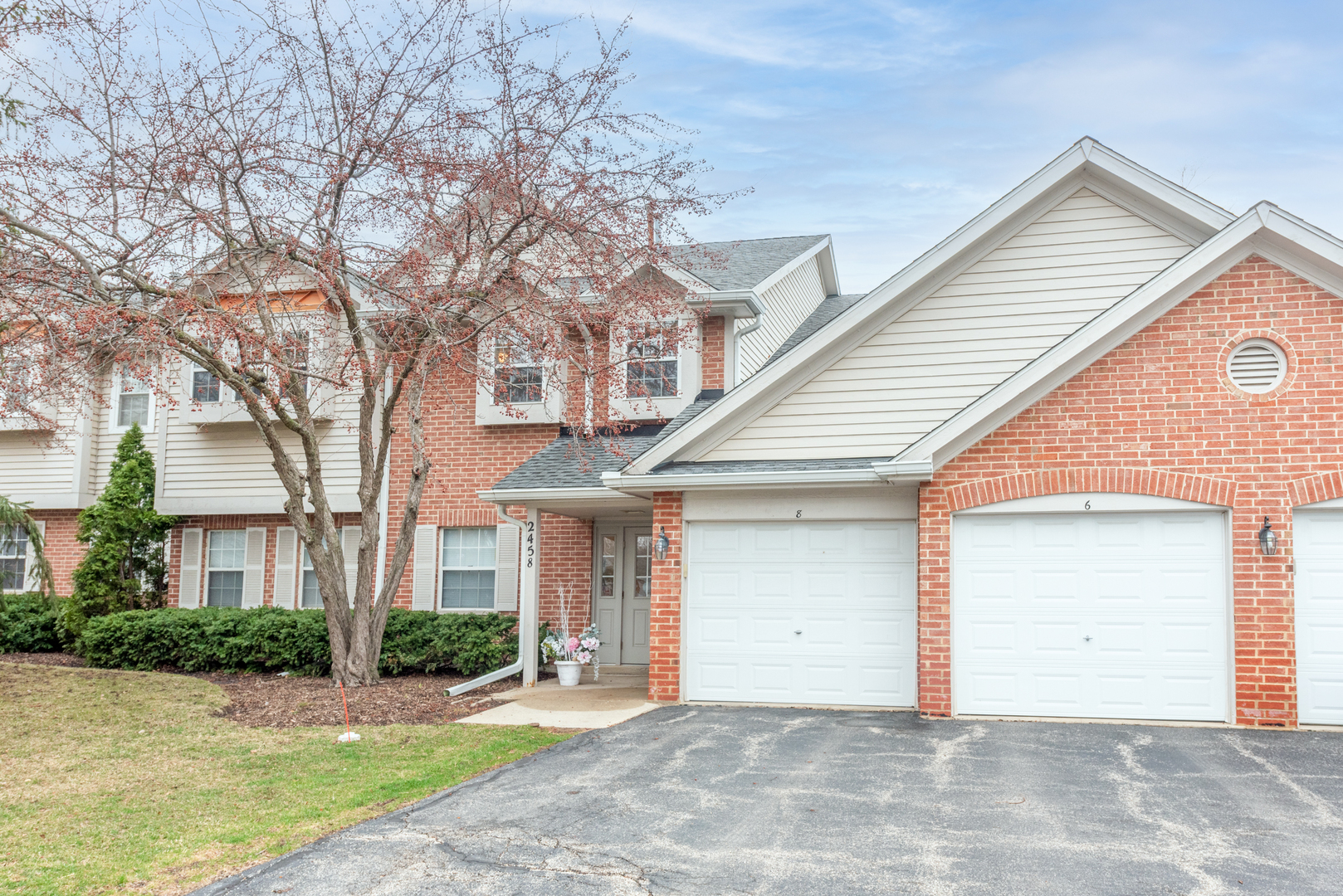 2458 Charleston Drive, Unit 6 Schaumburg, IL 60193 - Photo 1 of 31 a front view of a house with a yard and potted plants