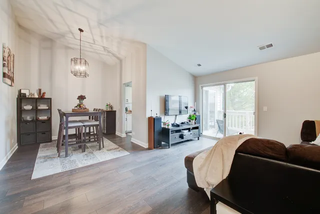 a living room with furniture a dining table and a wooden floor