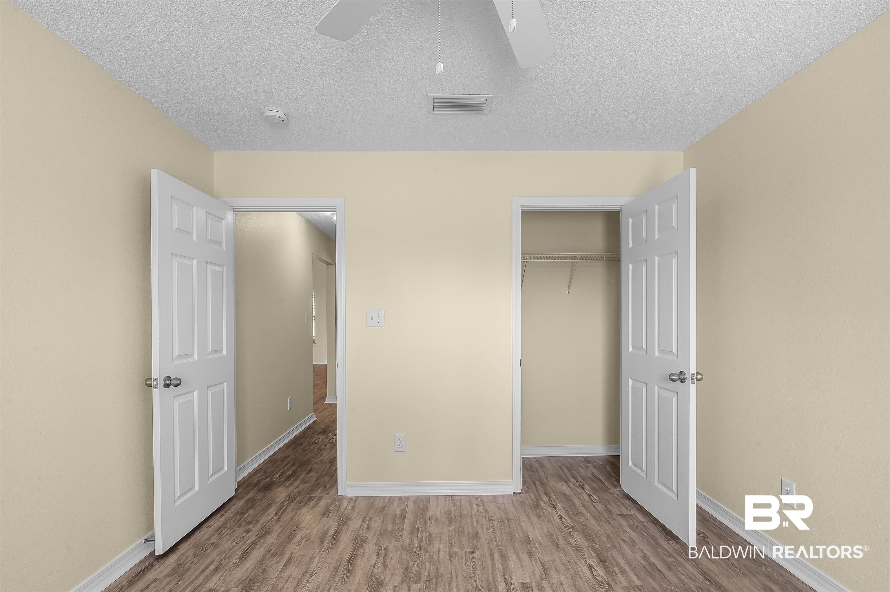 12443 Venice Boulevard Foley, AL 36535 - Photo 50 of 59 Unfurnished bedroom featuring a textured ceiling, wood-type flooring, ceiling fan, and a closet