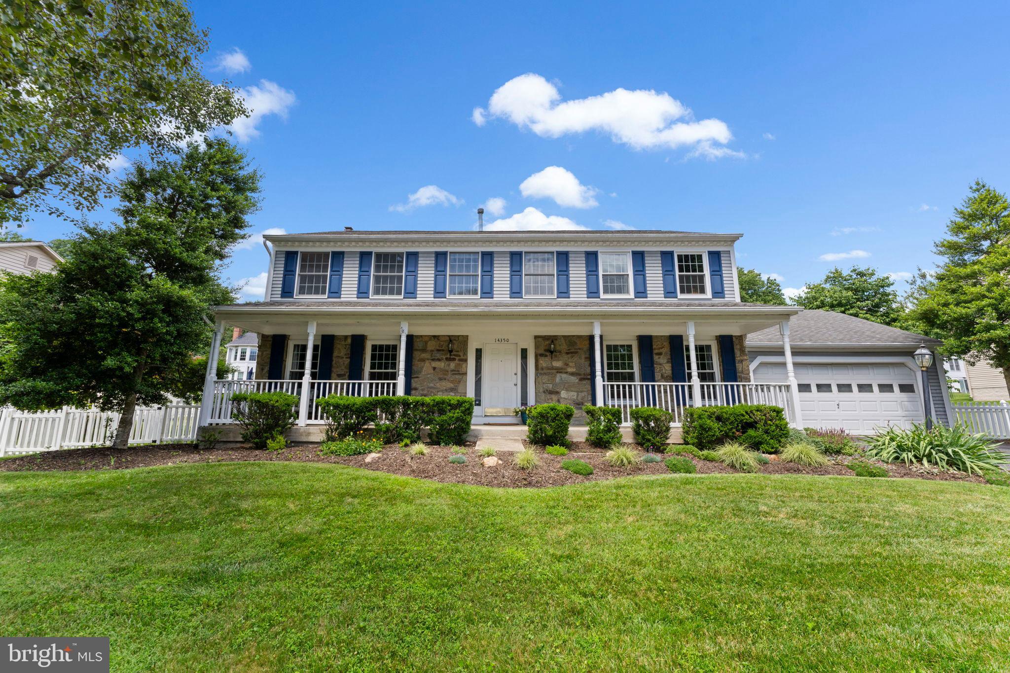 a front view of a house with a garden and plants