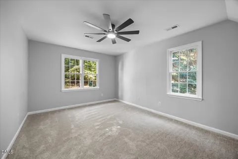 a view of a big room with windows and chandelier fan