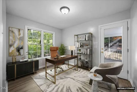 an empty room with windows fireplace and wooden floor