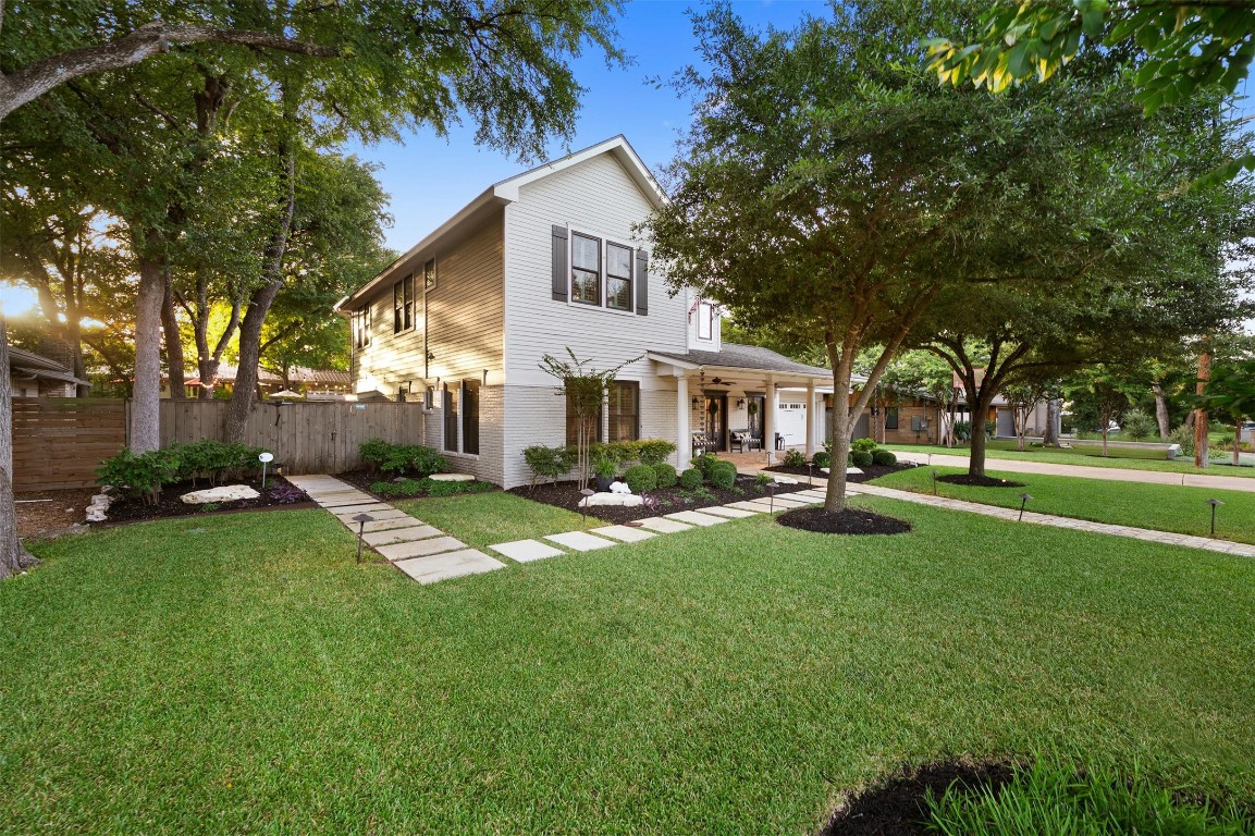 a front view of a house with yard and green space