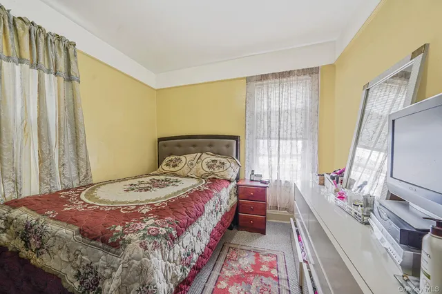 a bedroom with a bed wooden floor and a chair