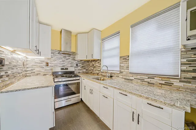 a kitchen with stainless steel appliances granite countertop a sink and a stove
