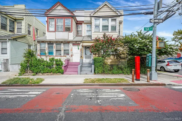 a view of a white house with a yard and plants